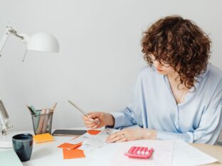 Foto de mulher escrevendo em um papel para simbolizar o tema Como preencher um recibo