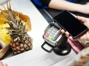 pessoa pagando com o celular numa maquininha: link de pagamento parcelado